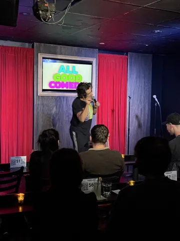 A view across the audience towards a comedian on the All Good Comedy stage