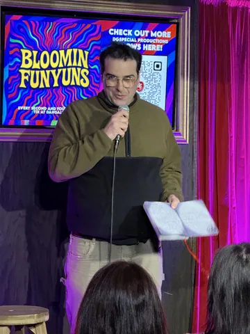 A performer holding notes and a microphone at Bloomin Funyuns