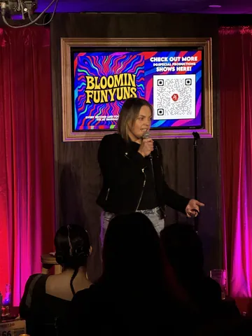 A comedian in a black outfit on the Bloomin Funyuns stage