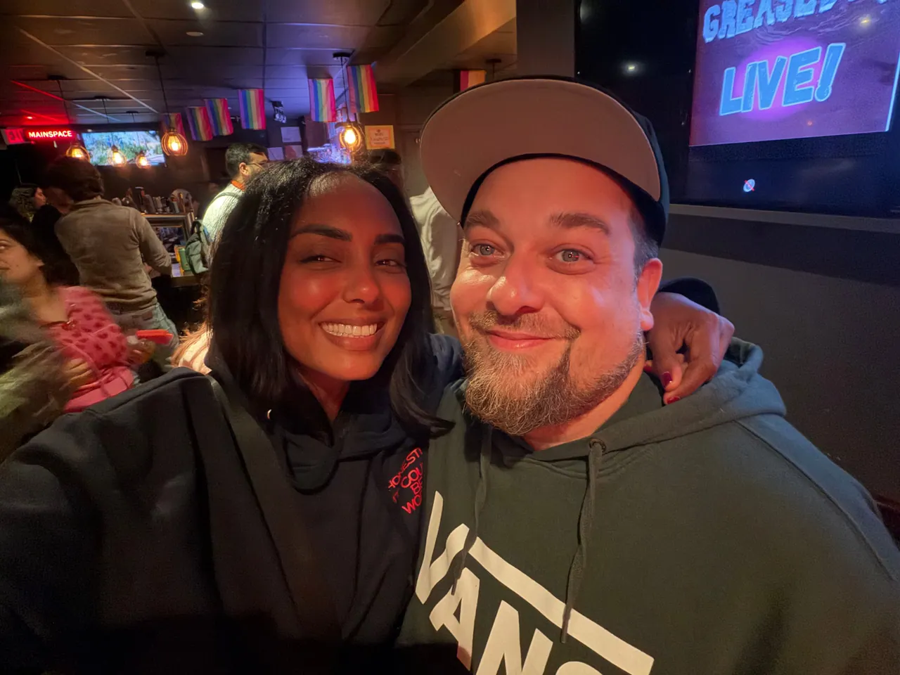 Two people smiling together for a selfie inside a venue