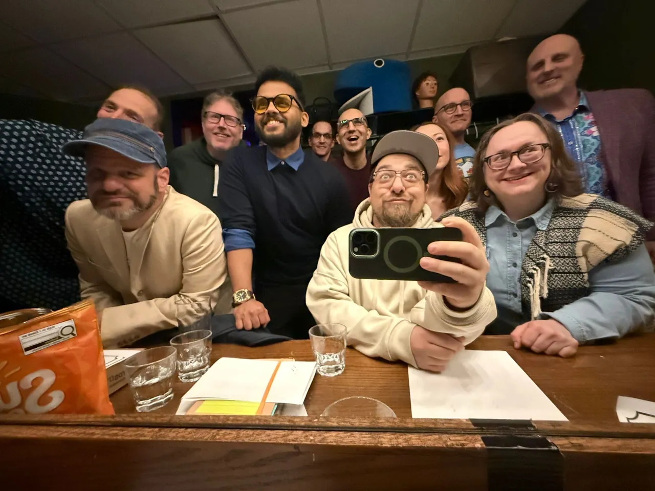 A large group leaning into a backstage mirror photograph